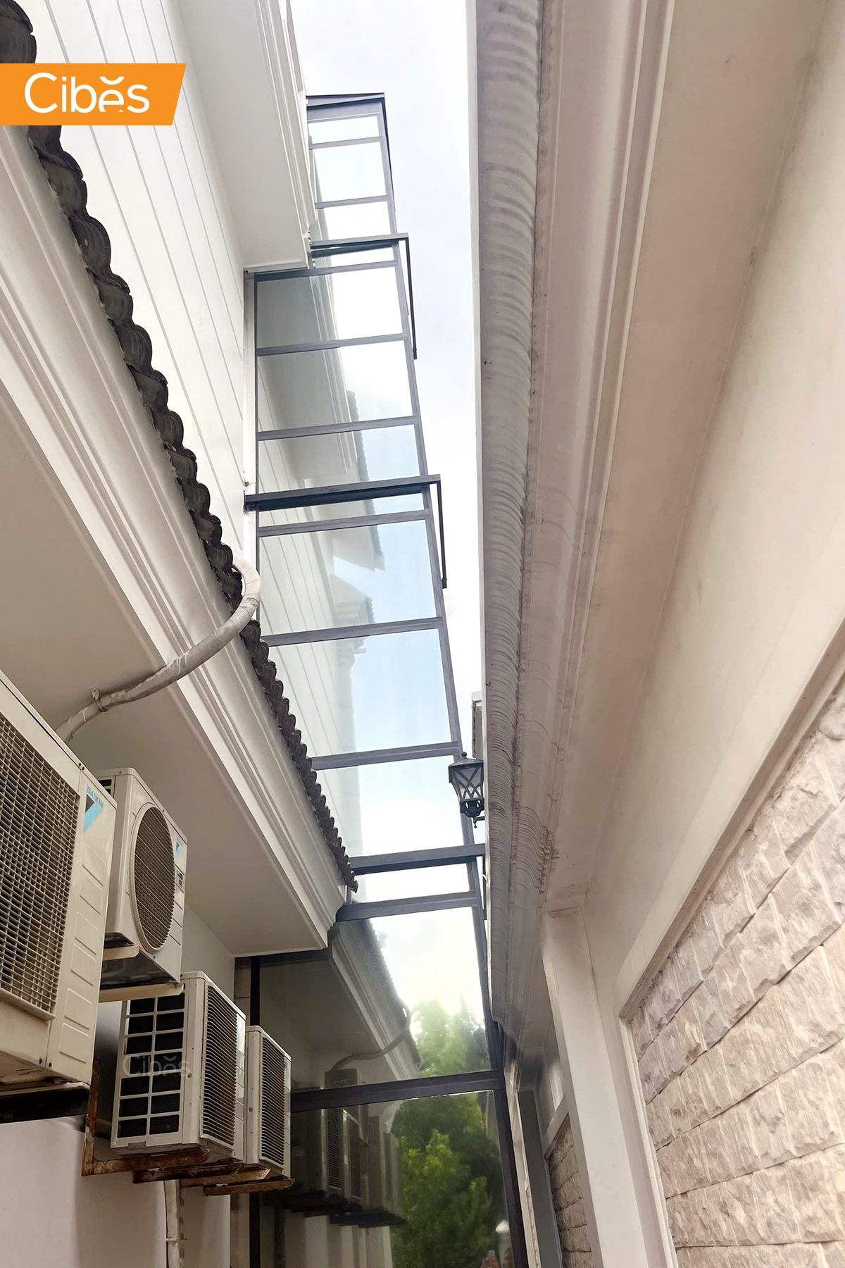 Thang máy gia đình ngoài trời lắp bên hông nhà ống bằng kính