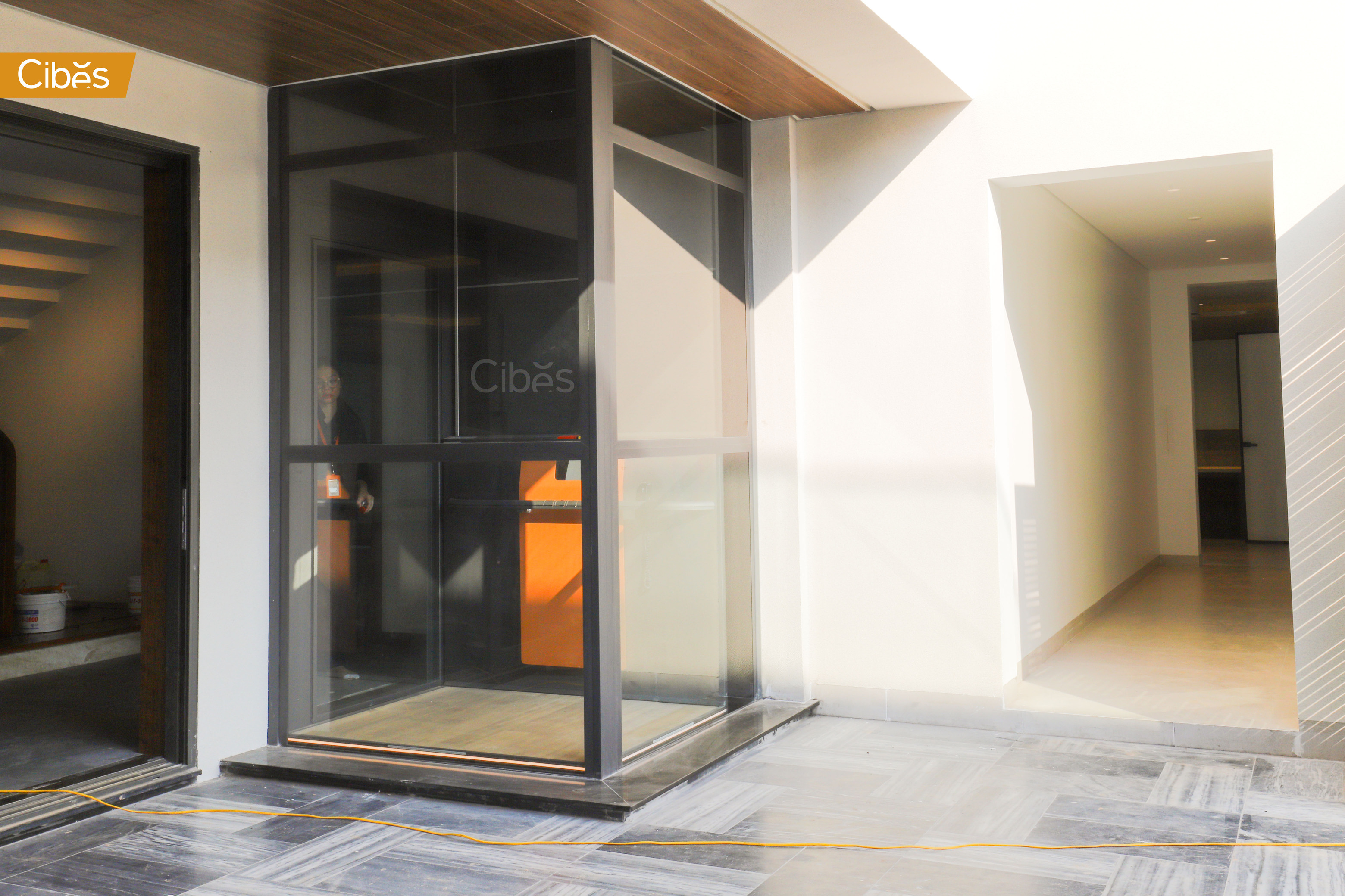 Thang máy gia đình ngoài trời lắp bên hông nhà ống bằng kính