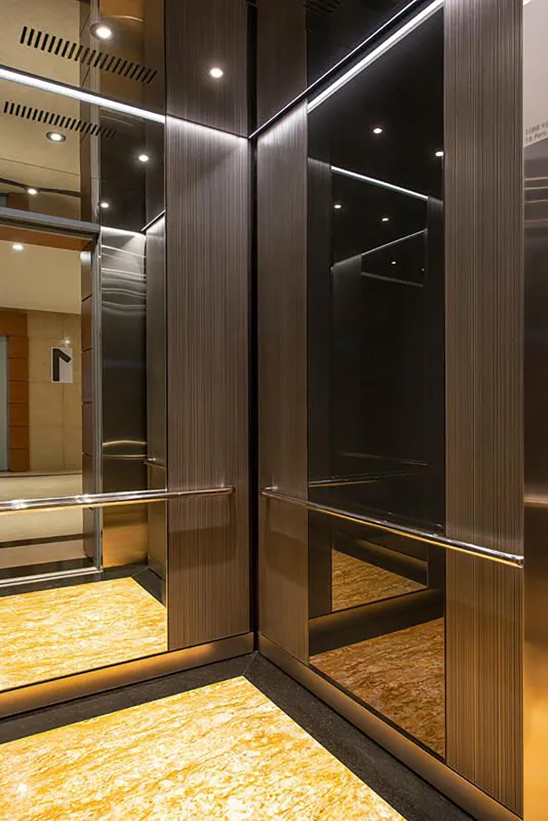 Trang trí trần thang máy bằng ốp tráng gương giúp mở rộng không gian, song lại dễ bị trầy xước