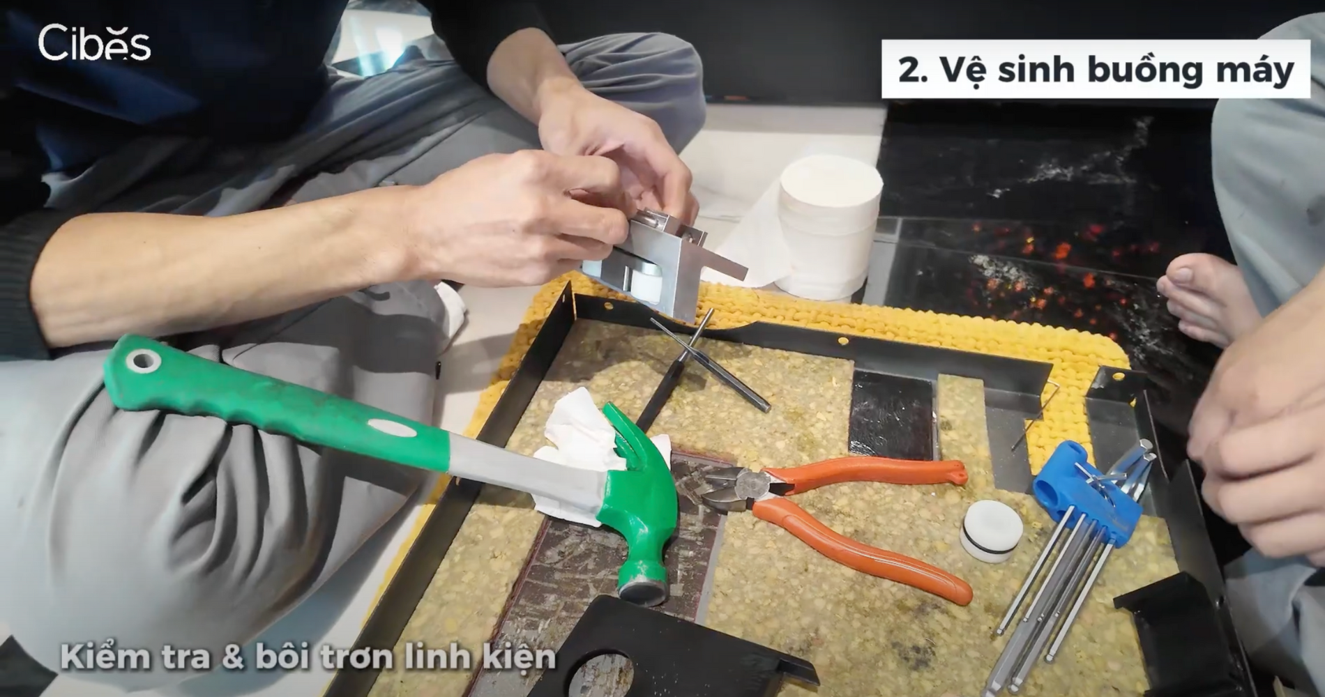 Kỹ thuật viên đang vệ sinh linh kiện thang máy bằng dầu chuyên dụng chính hãng